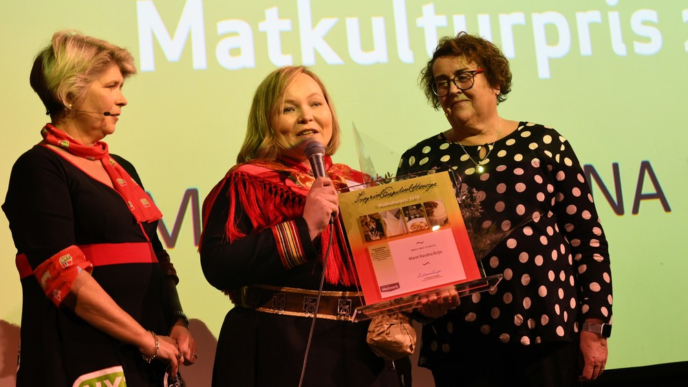 RØRT: Prisvinner Maret Ravdna Buljo i midten. Til venstre: Direktør i stiftelsen Matmerk, Nina Sundqvist. Landbruks- og matminister Olaug Bollestad til høyre.  FOTO: MATMERK